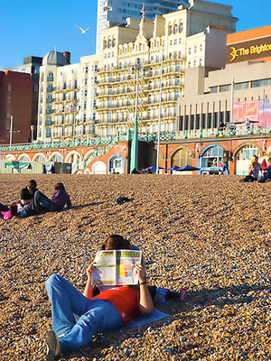Lehden lukija Brightonin rannalla
