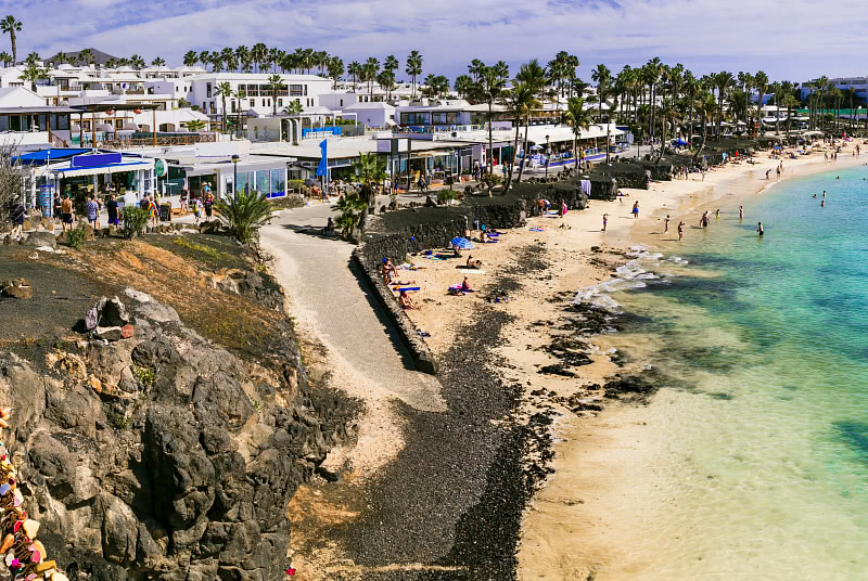 Majapaikkoja rantapromenadin takana, edustalla ranta, Lanzarote