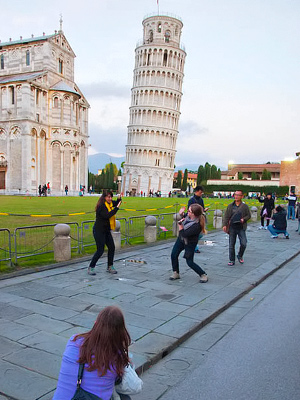 Turisteja Pisan kaltevaa tornia kuvaamassa